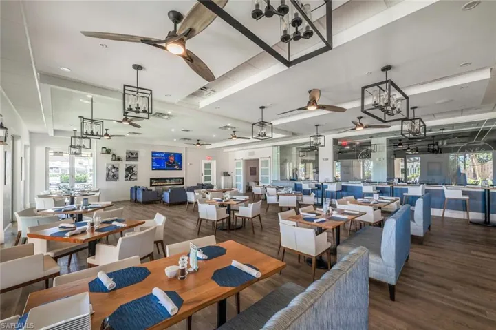 Spacious dining area featuring wood-finish flooring, recessed lighting, and multiple ceiling fans