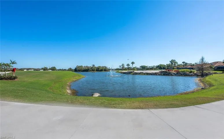 Expansive waterscape featuring a central fountain and lush green landscaping