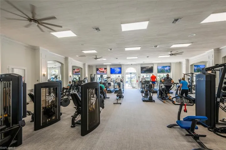 Fitness center featuring extensive exercise equipment and carpet flooring