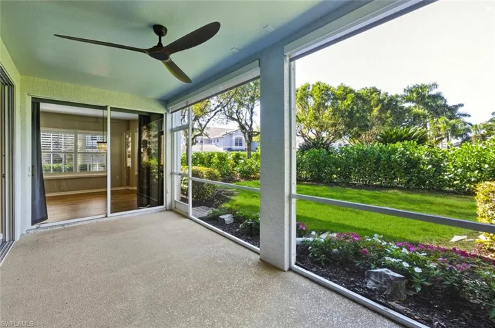 Screened patio with a ceiling fan, textured flooring, and sliding glass doors