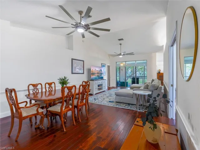 Dining area featuring dark wood finished floors, lofted ceiling, and ceiling fan