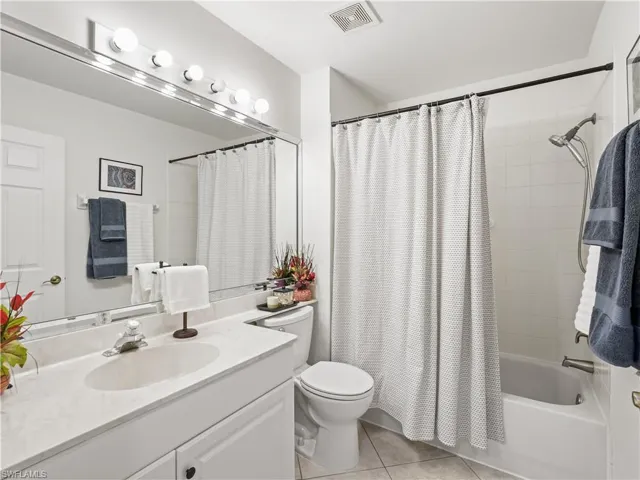 Full bathroom featuring vanity, light tile patterned flooring, and shower / bathtub combination with curtain