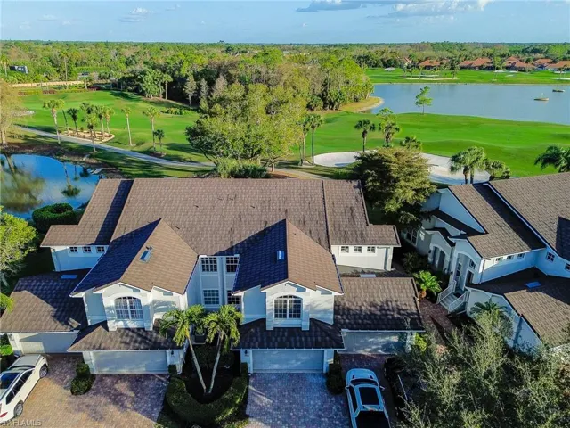 Aerial perspective of suburban area with a nearby body of water and a golf club
