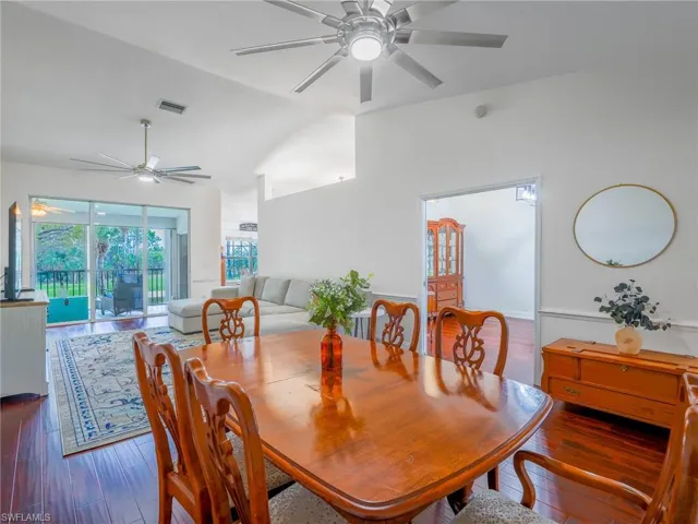 Dining room with hardwood / wood-style floors, ceiling fan, and lofted ceiling