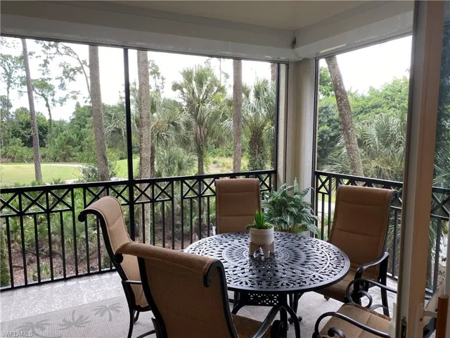 Sunroom / solarium featuring view of scattered trees