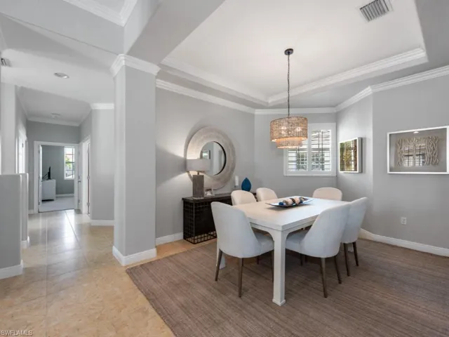 Dining space featuring light tile patterned flooring and ornamental molding