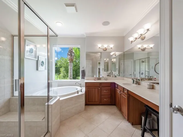 Bathroom with vanity, separate shower and tub, tile patterned flooring, ornamental molding, and a chandelier