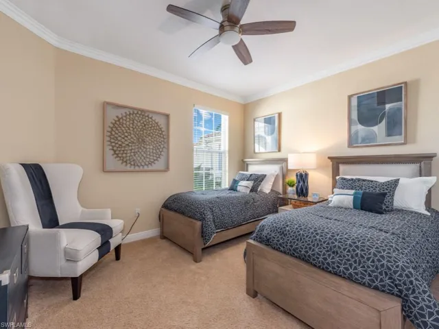 Carpeted bedroom with ceiling fan and ornamental molding