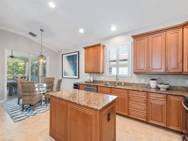 Kitchen featuring light tile patterned floors, a kitchen island, tasteful backsplash, and sink