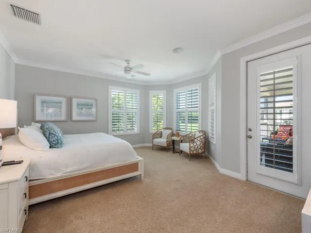 Carpeted bedroom with ceiling fan, access to exterior, and crown molding