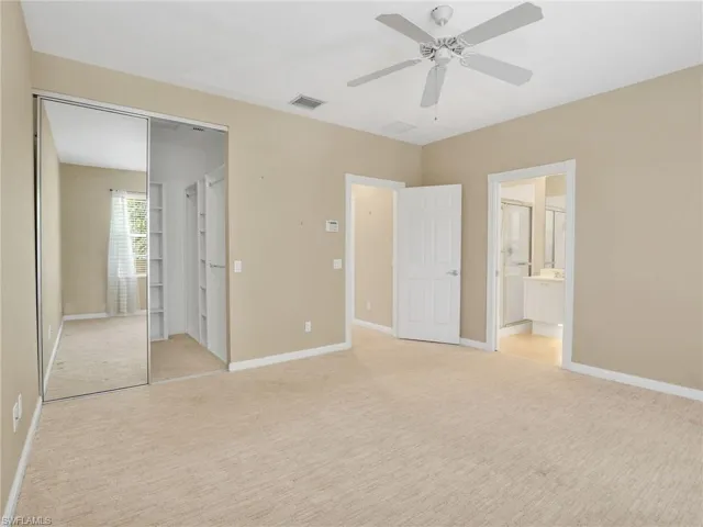 Unfurnished bedroom with light colored carpet, a closet, and baseboards