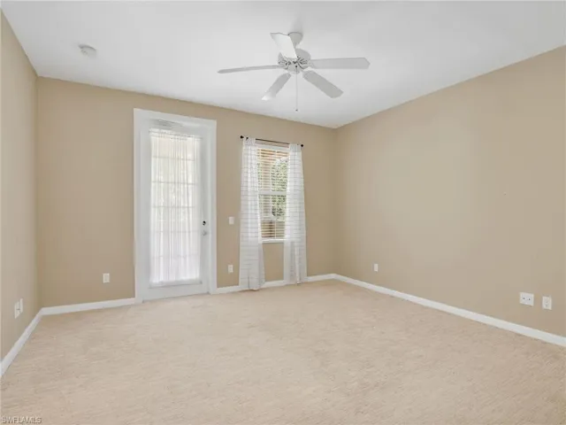 Spare room with ceiling fan, baseboards, and light carpet