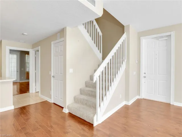 Foyer with light wood finished floors, stairs, and baseboards