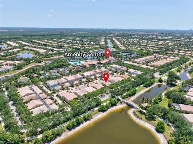 Aerial view of property and surrounding area featuring nearby suburban area and a large body of water