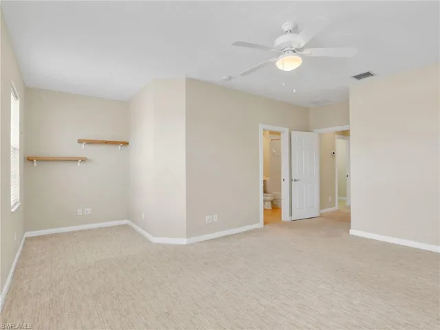 Empty room featuring a ceiling fan, carpet flooring, and baseboards