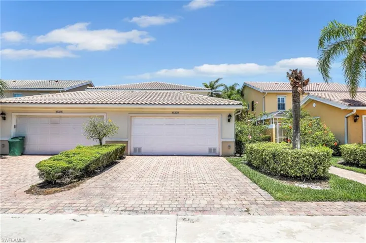 View of front of home featuring stucco siding, driveway, and a tile roof