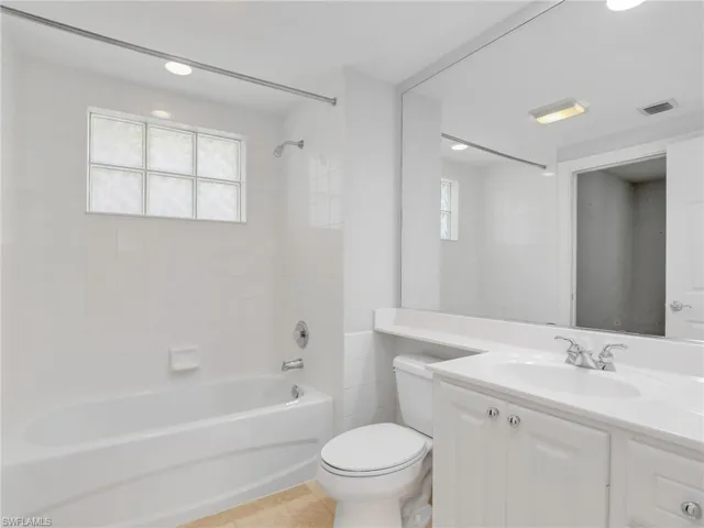 Bathroom with washtub / shower combination, toilet, vanity, recessed lighting, and tile patterned flooring