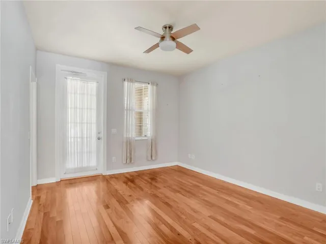 Unfurnished room featuring a ceiling fan, light wood-style floors, and baseboards