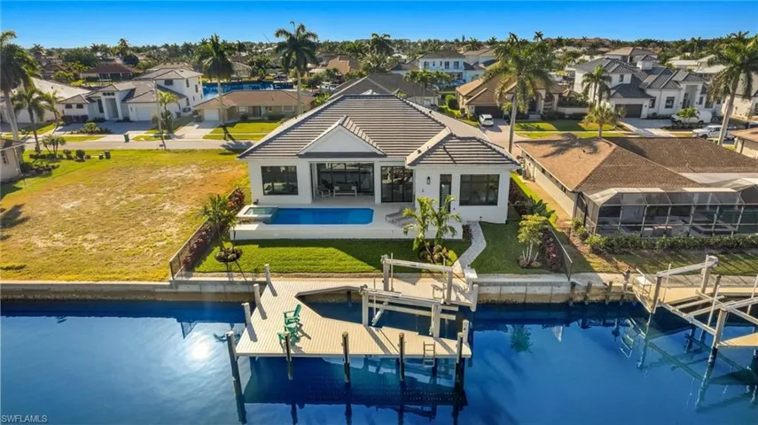 Rear view of house featuring boat lift, a residential view, an outdoor pool, and a patio area