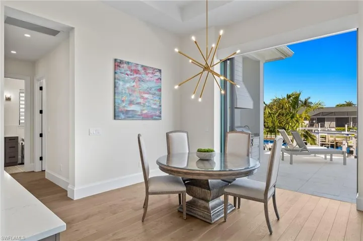 Dining room with light wood-style floors, recessed lighting, baseboards, and a chandelier