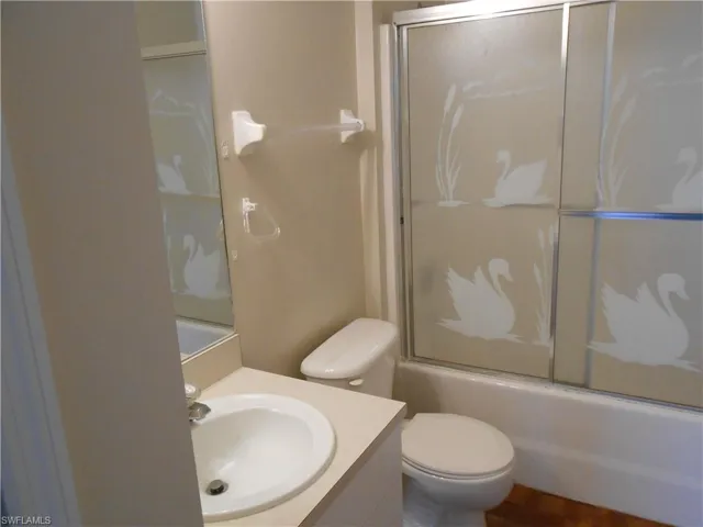Full bathroom featuring vanity, combined bath / shower with glass door, and wood finished floors
