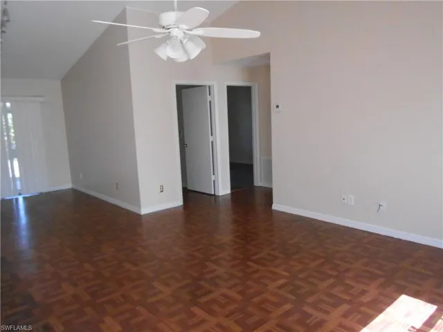 Unfurnished room featuring vaulted ceiling, parquet flooring, and ceiling fan