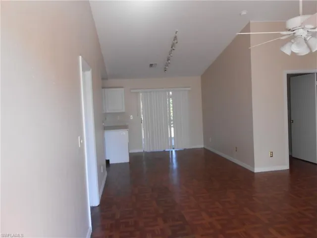 Unfurnished living room with rail lighting, parquet floors, and ceiling fan