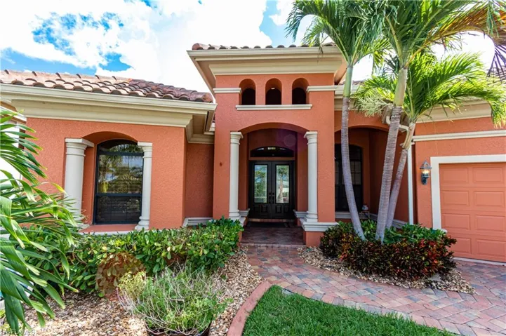 Property entrance featuring french doors, a tile roof, and stucco siding