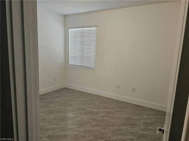 Spare room with baseboards and tile patterned floors