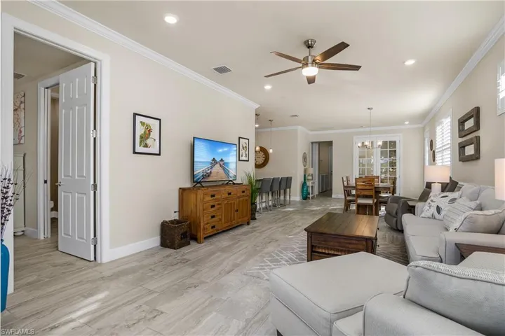 Living room featuring with crown molding, plank tile flooring, 8' doors.