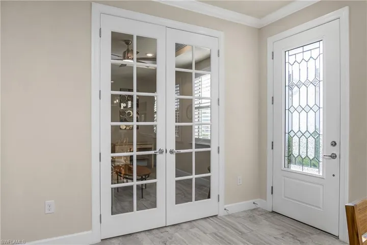 Entrance foyer featuring a healthy amount of sunlight, crown molding, and french doors