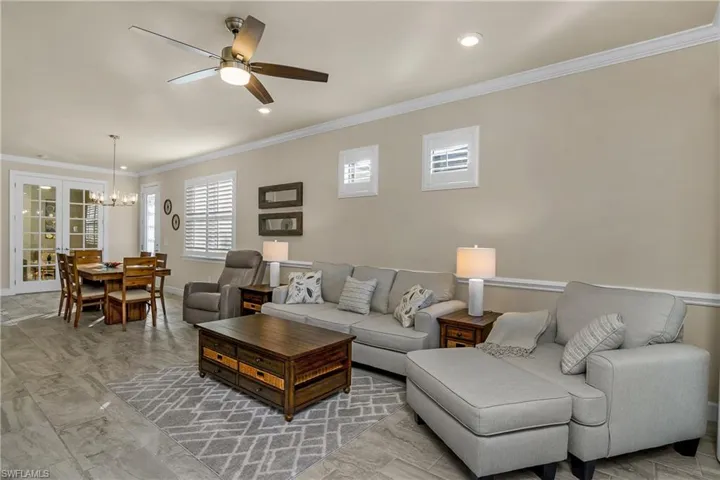 Living room with crown molding, french doors and plantation shutters