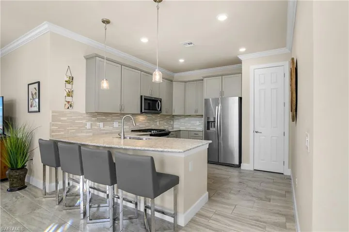 Kitchen with peninsula breakfast bar and quartz counter tops.