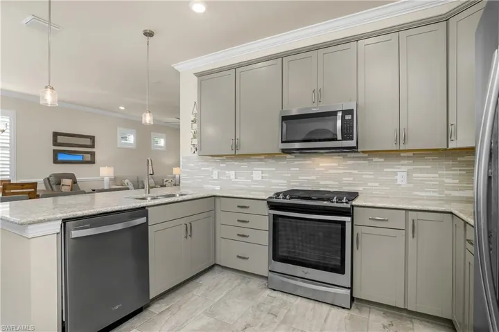Kitchen featuring quartz counters, 5 burner gas stove, and pendant light fixtures