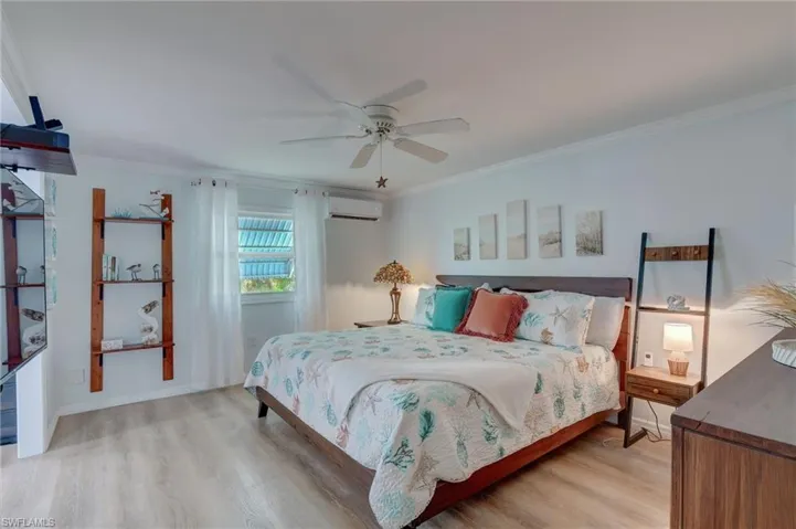 Bedroom featuring light wood finished floors, ceiling fan, and ornamental molding
