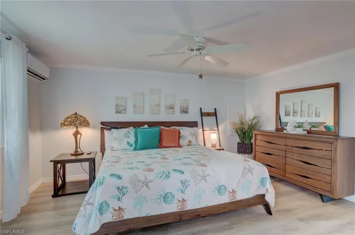 Bedroom with light wood finished floors, a ceiling fan, and ornamental molding