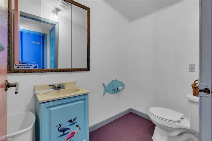 Bathroom featuring visible vents, baseboards, toilet, crown molding, and vanity