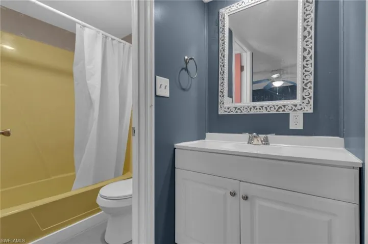 Bathroom featuring toilet, shower / tub combo, and vanity