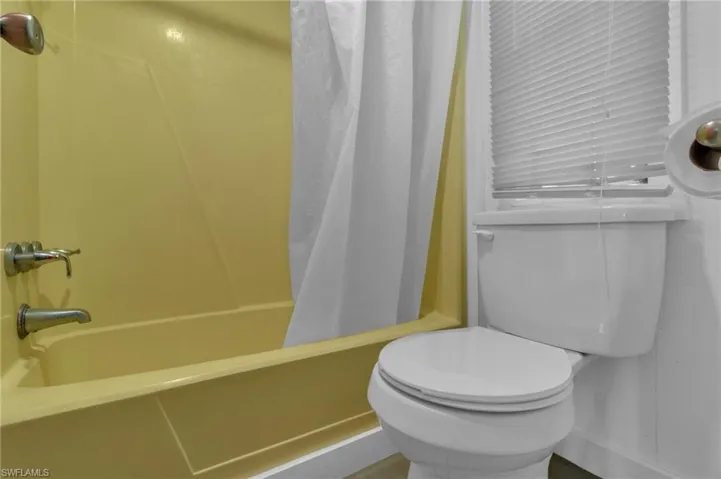 Full bath featuring shower / bath combo and toilet