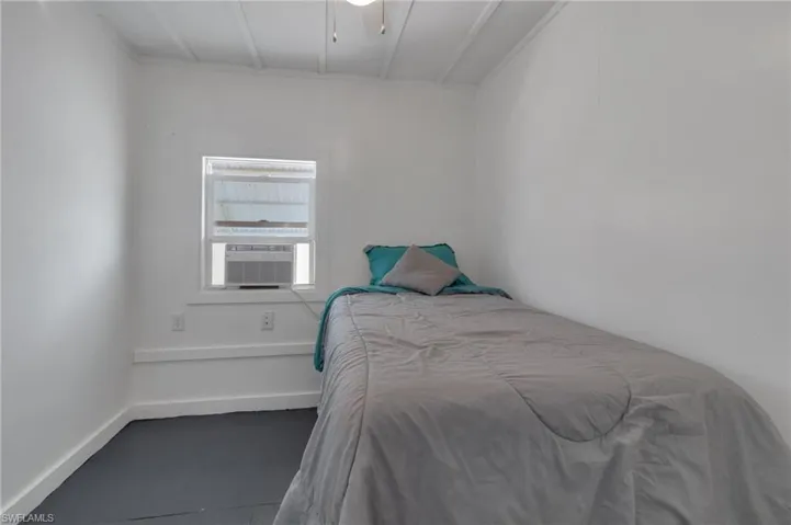 Bedroom featuring cooling unit and baseboards