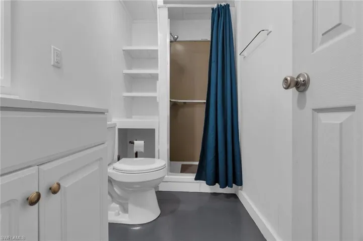Bathroom with toilet and a shower with shower curtain