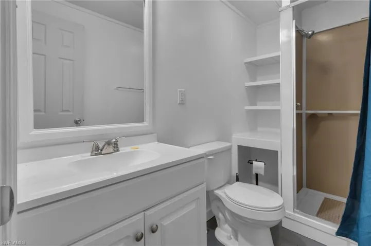 Full bathroom with toilet, a stall shower, and vanity