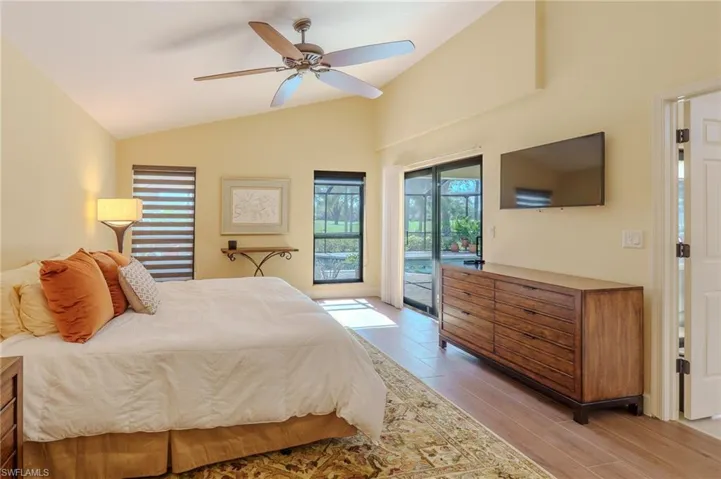 Bedroom featuring vaulted ceiling, access to outside, light wood-style flooring, and ceiling fan