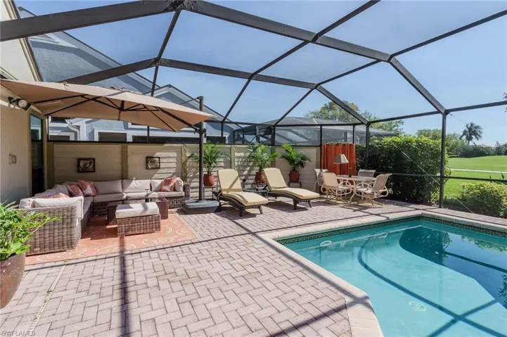 Outdoor pool with glass enclosure, a sunroom, outdoor furniture, and a patio area