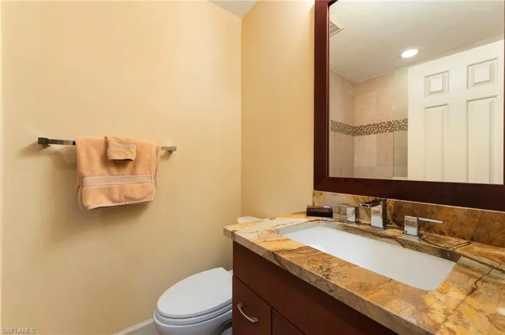 Bathroom featuring vanity and decorative backsplash