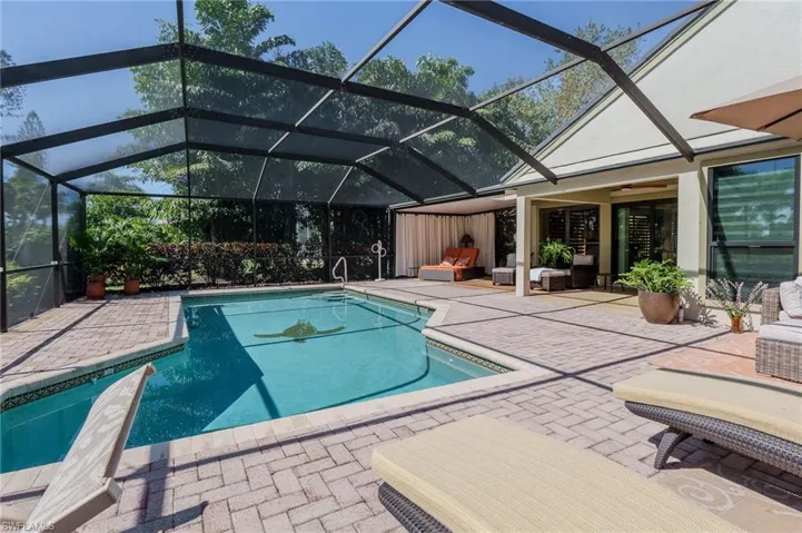 Swimming pool with glass enclosure, a patio, a sunroom, and outdoor furniture
