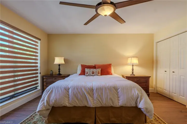 Bedroom with wood finished floors, a ceiling fan, and a closet