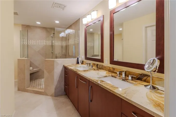 Full bath with double vanity, walk in shower, recessed lighting, and light tile patterned floors