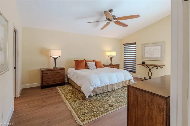 Bedroom featuring wood finished floors, ceiling fan, and vaulted ceiling