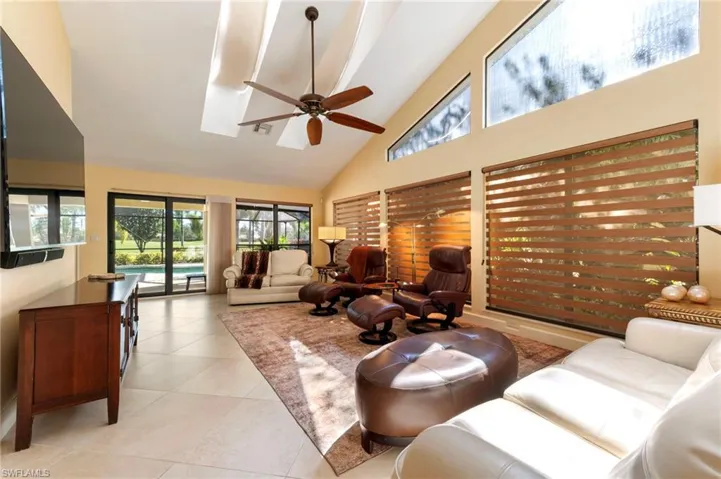 Living area featuring ceiling fan, vaulted ceiling, and light tile patterned floors